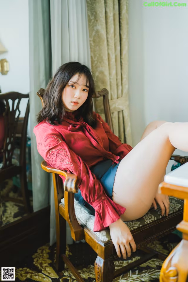 A woman sitting in a chair with her legs crossed.
