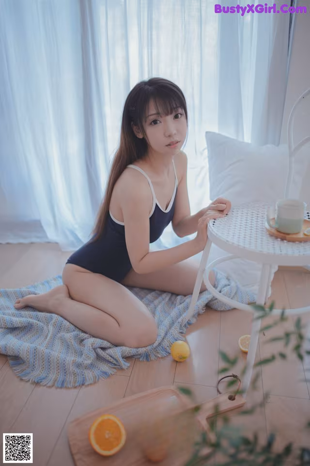 A woman sitting on the floor next to a table with a cup of coffee.