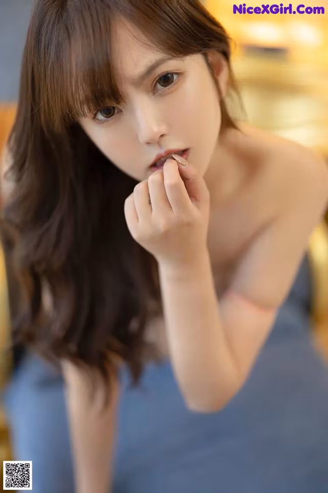 A woman in a blue dress is posing for a picture.