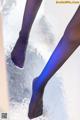 A close up of a woman's legs in blue tights.