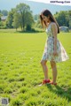 A woman standing in a field of green grass.