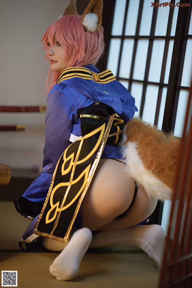 A woman with pink hair is sitting on the floor.