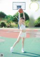 A woman holding a basketball on top of a basketball court.