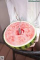 A person holding a slice of watermelon with a spoon in it.