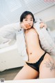 a woman in a white jacket and black panties posing for a picture