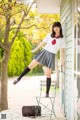 A woman in a school uniform is posing for a picture.