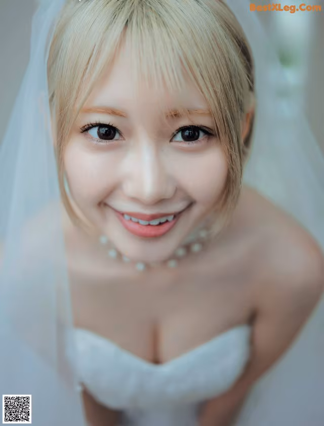 A woman in a wedding dress with a veil over her head.
