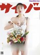 A magazine with a woman holding a bunch of flowers.